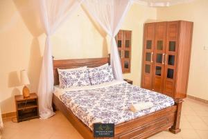 KakamegaMilimani Resort Kakamega的一间卧室配有一张带天蓬的床
