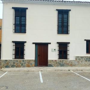 AlatozCasa rural El Molino 2的白色的建筑,设有棕色的门和窗户