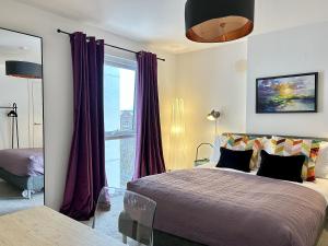 贝尔法斯特Central Belfast Apartments Sandford的一间卧室配有一张带紫色窗帘的床和窗户。