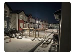 埃德蒙顿Edmonton的一条雪覆盖的街道,晚上有房子