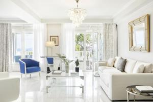 尼基季The Danai的白色的客厅配有白色的沙发和蓝色的椅子