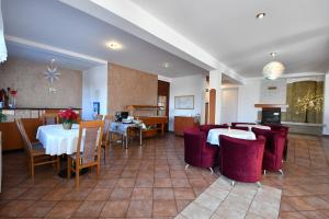 Vysoke Tatry - Tatranska Lesna里斯拉旅馆的一间设有白色桌子和红色椅子的餐厅