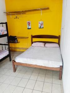 乌巴图巴Camping estrela Ubatuba的黄色墙的房间里一张床位