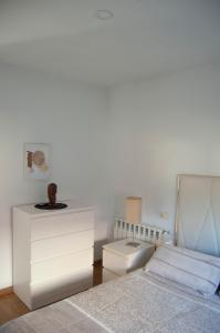 拉斯卡尔达斯Casa en Villa Termal Las Caldas的一间白色卧室,配有一张床和一个梳妆台