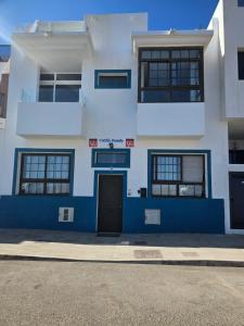科蒂略Apartamentos Cotillo Family的前方有门的蓝色和白色建筑