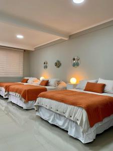 奇廉Alojamiento RBOY Las Mariposas的一间卧室配有两张带橙色床单的床