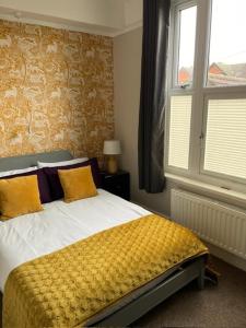 PakefieldMost Easterly (North)的一间卧室配有一张带黄色床单的床和一扇窗户。