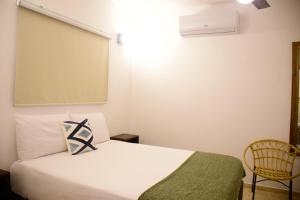 圣塔芭芭拉-山美纳Hostal Marina Samana的卧室配有白色的床和大屏幕