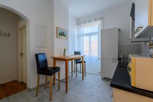 沙夫豪森Wifi Netflix free parking Gruben Apartment的厨房配有桌椅和冰箱。