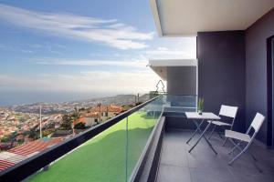 丰沙尔Dream View的客房设有带桌椅的阳台。