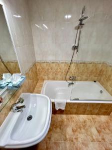 La Pola de GordónBicis & Vacas的浴室配有白色水槽和浴缸。
