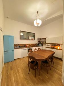 巴黎Maison de ville d'architecte parking gratuit的厨房配有木桌和蓝色冰箱。