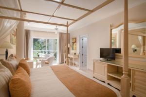 拉斯特拉纳斯Bahia Principe Grand El Portillo - All Inclusive的一间带床和电视的客厅