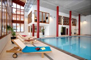 阿克1800Appart'Hotel Prestige Odalys Eden的一个带躺椅的室内游泳池和泳池屋