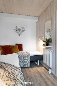 温德托尔夫Ferienhaus Marina Lounge Wendtorf的一间卧室配有一张床和镜子