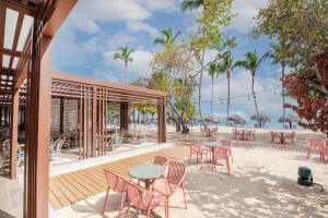 拉斯特拉纳斯Bahia Principe Grand El Portillo - All Inclusive的海滩上带桌椅的庭院