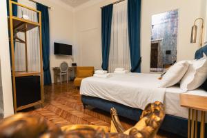 塞萨洛尼基Villa Clio, a Luxury Collection的一间卧室配有一张带蓝色窗帘的大床