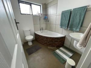 霍维克The Stables, Central Garden Cottage in Howick的带浴缸、卫生间和盥洗盆的浴室