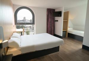 德勒B&B HOTEL Dreux Centre的卧室配有白色的床和窗户。