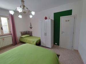 圣欧费米亚拉默齐亚Casetta GGG的一间卧室设有两张床和绿色的墙壁