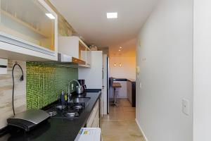 阿雷格里港Apartamento Espaçoso & Aconchegante - 3 quartos的厨房配有水槽和炉灶