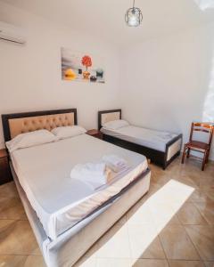 卡萨米尔Vila Feimi的一间卧室配有两张床和椅子