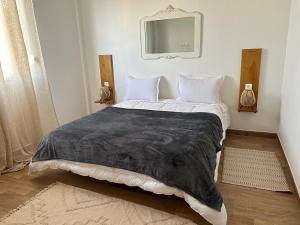 贝贾亚Villa la crête的一间卧室配有一张大床和黑色毯子