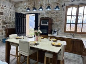 贝贾亚Villa la crête的厨房配有大桌子、椅子和台面