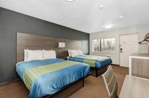 格罗夫城Grove City Travel Inn的酒店客房设有两张床和窗户。