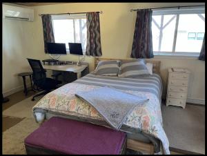波特兰Guest Space on the Portland Peninsula的一间卧室配有一张床和一张带电脑的书桌