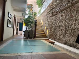卡塔赫纳埃巴诺967号酒店的走廊设有楼梯和石墙