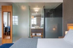 波尔图Santa Catarina FLH Suites的一间卧室设有一张床和一间浴室。