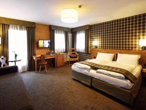 佩斯库拉奥索治奥酒店的一间卧室配有一张床和一张书桌