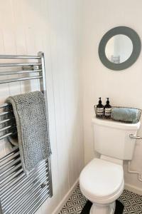 GurnardDriftwood的浴室设有白色的卫生间和镜子