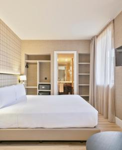 巴塞罗那阿克塔城市47就的卧室配有白色的大床和架子