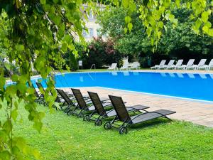 佐洛恰尼Thermal Valley Apartman - Batthyány Villapark的游泳池旁的一排躺椅