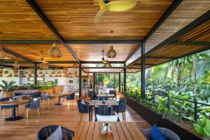希门尼斯港El Remanso Rainforest Lodge的一间设有桌椅的餐厅,种植了植物