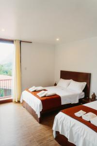 San CarlosDonce Extremo的一间卧室设有两张床和大窗户