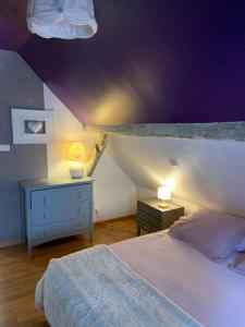 伊尔基希-格拉芬斯塔登la Maison d'à coté的一间卧室设有一张床和紫色天花板