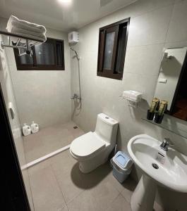 金宁乡蓝山客栈的白色的浴室设有卫生间和水槽。