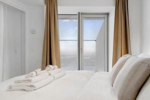 奥胡斯Penthouse paradise on 39th floor的窗户前的白色床和毛巾