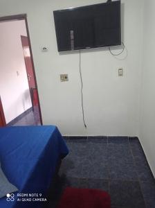 龙多诺波利斯Apartamento Aconchegante 4的墙上配有平面电视的房间