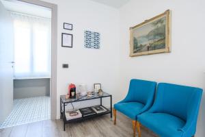 Ozzano MonferratoVilla Rocco Country House的一间设有两张蓝色椅子和一张桌子的房间