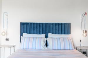 Ozzano MonferratoVilla Rocco Country House的一张带蓝色床头板和白色枕头的床