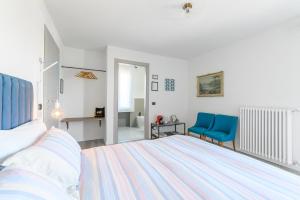 Ozzano MonferratoVilla Rocco Country House的一间卧室配有一张床和两张蓝色椅子