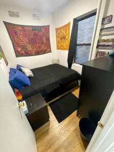 纽约Charming One-Bedroom Apartment in South Chelsea的一间小卧室,配有一张黑色的床和一个窗户