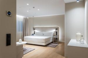 巴塞罗那皇家大道酒店的白色卧室配有床和桌子