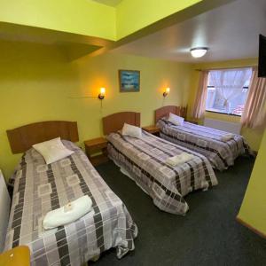 波韦尼尔Hotel Yagan Porvenir的黄色墙壁的房间里设有三张床