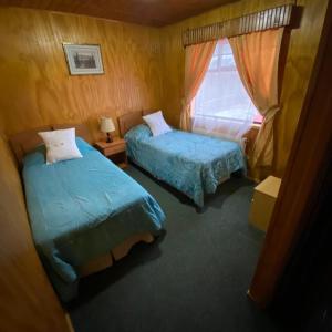 波韦尼尔Hotel Yagan Porvenir的一间卧室设有两张床和窗户。