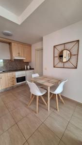 圣米格尔德阿沃纳Sunny Suite的厨房配有木桌和白色椅子